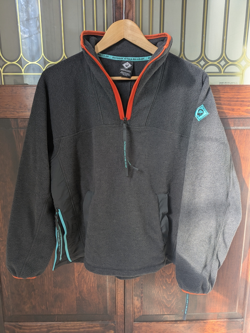 Afro Outdoors x REI Co-Op Fleece Pullover with Orange Trim and Teal Accents